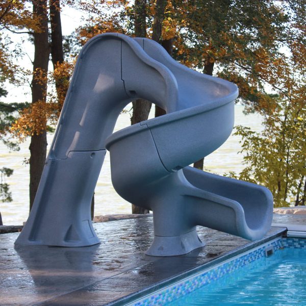 Tsunami Deck Mounted Pool Slide (GPPSTS) by a pool, framed by autumn trees, a lake, and blue sky.
