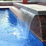 CMP Natural Wonders 48-inch white pool waterfall with back port|CMP pool waterfall water curtain close-up|Natural Wonders waterfall mounted on pool wall|CMP waterfall and fountain pool combination|Raised pool wall with CMP white waterfall feature