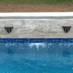 CMP Natural Wonders 48-inch white pool waterfall with back port|CMP pool waterfall water curtain close-up|Natural Wonders waterfall mounted on pool wall|CMP waterfall and fountain pool combination|Raised pool wall with CMP white waterfall feature