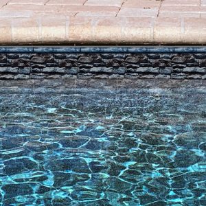 A stylish Atlantic Stone/Sea Slate pool border accents a modern pool area in Long Island, NY.