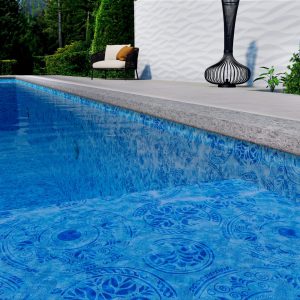 A close-up of a blue pool features Terracina All Over Pattern tiles, a patio chair, plants, and decor.