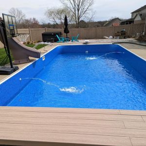 A Blue Quartz All Over Pattern pool with water, slide, and furniture in Long Island & Queens, NY.