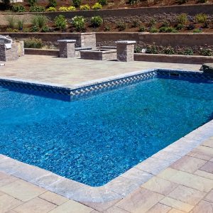 Corolla Beach Tile surrounds a rectangular pool deck, enhancing an Outer Banks floor garden in Queens.