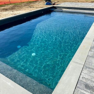 A rectangular Midnight Opal pool with clear blue water, ideal for pool supplies in Long Island and Queens.