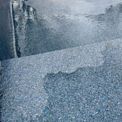 Close-up of wet poolside steps in New York, finished with Midnight Opal, in Long Island & Queens.