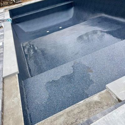 A Midnight Opal in-ground pool liner is installed as a pool is filled with supplies in Long Island, NY.