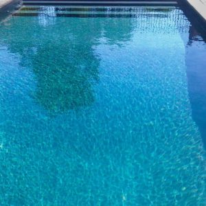 Island Onyx All Over Pattern tile with blue reflections enhances NY pools in Long Island and Queens.