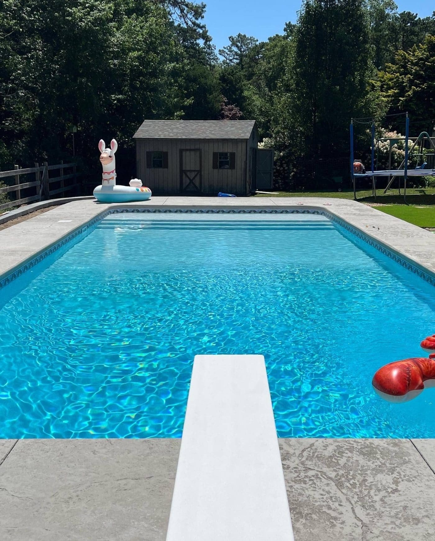 A sparkling backyard pool with Caswell Beach Tile and Sandy Point Floor, perfect for Long Island homes.