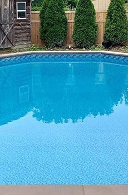 A Luxe Gemstone Tile Ocean Breeze floor adds elegance to a modern pool in Long Island, NY.