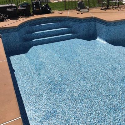 An empty pool features Luxe Gemstone Tile and Ocean Breeze Floor, ideal for Long Island and Queens.