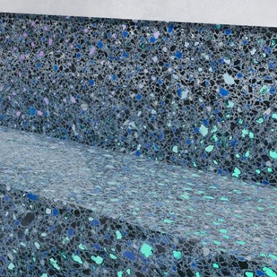Close-up of blue mosaic tile pool steps, bordered by grass and flowers, found in Long Island.