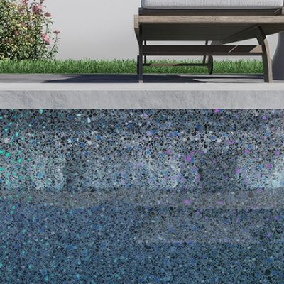 A Midnight Opal sun lounger sits poolside by blue mosaic tiles, grass, and flowers in Queens, NY.
