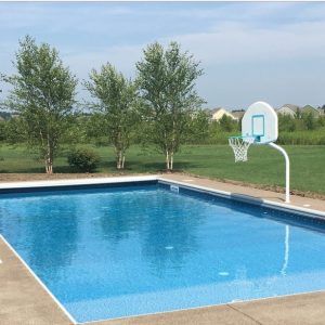 A rectangular outdoor pool features Palmetto Bay Tile/Brava Beach Floor, ideal for Long Island & Queens.