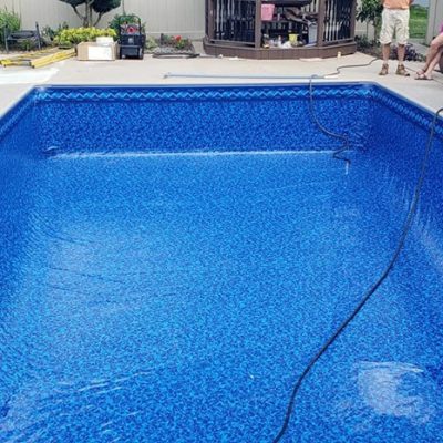 Outdoor pool area in Long Island with Royal Island Tile Sea Storm Floor and a landscaped garden patio.
