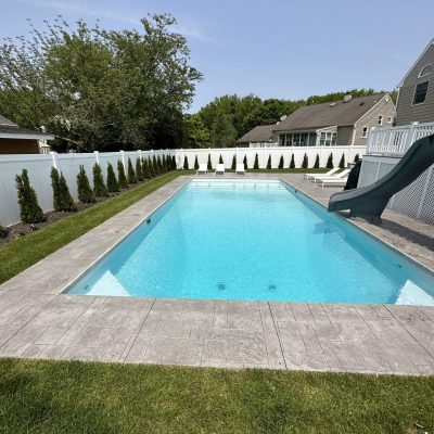 Caswell Beach Tile patio surrounds a backyard pool with Sandy Point Floor supplies in Long Island, NY.