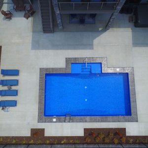 A rectangular blue pool features Diamond Cliff Tile and Blue Pointe Floor, ideal for NY summers in Long Island.