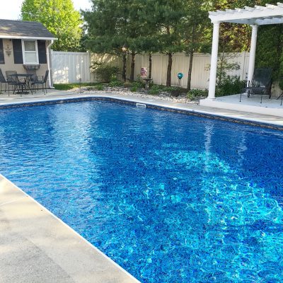 A backyard pool in Long Island features Runaway Bay Floor tiles for a stylish blue design.