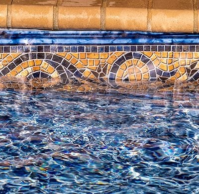 Blue water ripples in a NY pool bordered by Sandy Cay Tile and Runaway Bay Floor at the edge.