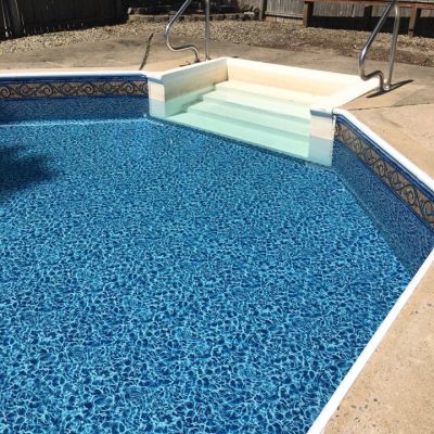 A backyard pool features Sandy Cay Tile with Runaway Bay Floor, available in Long Island & Queens, NY.