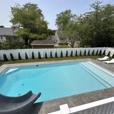 A rectangular NY backyard pool with Caswell Beach Tile, Sandy Point Floor, slide, lounge chairs, and supplies.