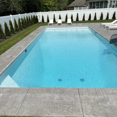 Caswell Beach Tile and Sandy Point Floor are shown installed beside a sparkling pool in Long Island.