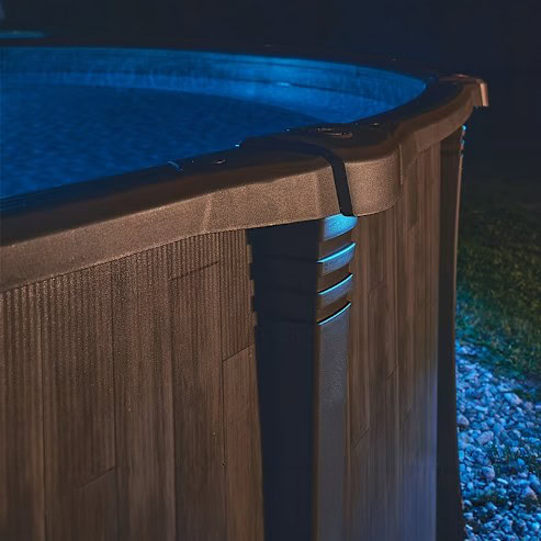 Close-up of Carvin StarGlow LED Pool Light 9413612001 illuminating an above-ground pool at night.