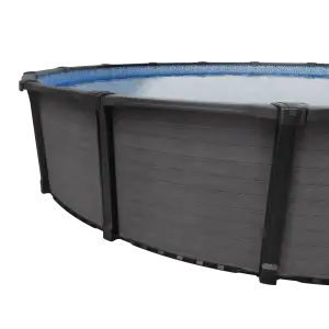 A close-up of a round, above-ground pool with a dark gray exterior and clear blue swimming water inside.