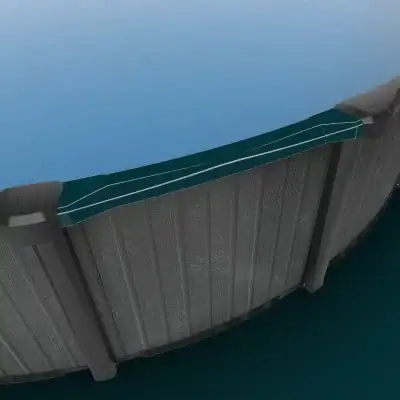 Close-up view of Ember Drift 27' Round Resin Above Ground Pool's gray curved wall in blue water.